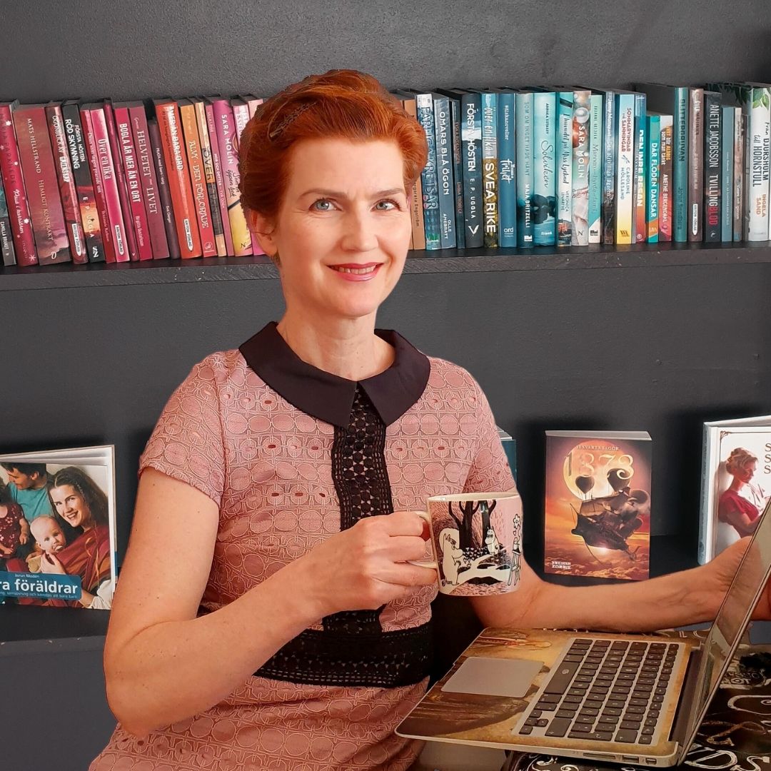 Författaren Jorun Modén vid en laptop. Böcker av hennes utgivna deltagare i bakgrunden.